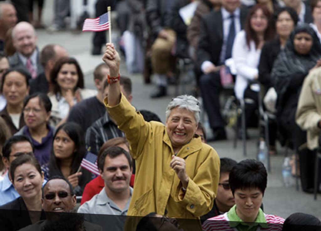 Person standing in a crowd holding a small American flag